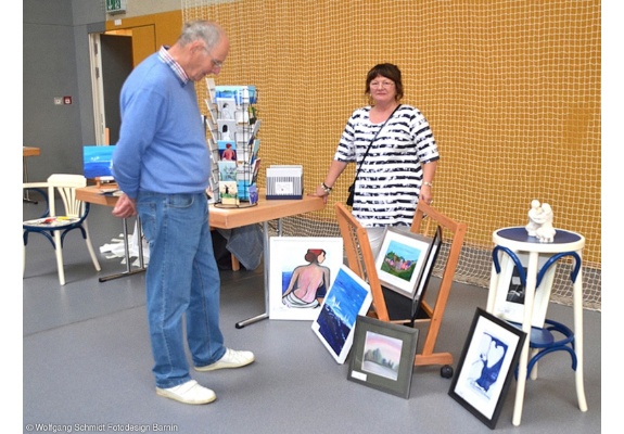 Besucher sieht sich die Bilder einer Malerin an